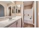 Bright bathroom featuring a white vanity with a large mirror and a separate shower/tub with wood look flooring at 823 Safflower Ct, Henderson, NV 89015