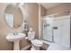 Bathroom with single pedestal sink, toilet, and tiled shower with glass doors at 823 Safflower Ct, Henderson, NV 89015