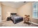Cozy bedroom features neutral colors, a bedside table and lamp, and a window with white shutters at 823 Safflower Ct, Henderson, NV 89015