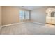 Neutral bedroom with plush carpeting, plantation shutters, and adjacent bathroom entrance at 823 Safflower Ct, Henderson, NV 89015