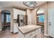 Bright kitchen island, white cabinets, stainless steel refrigerator, and wood flooring at 823 Safflower Ct, Henderson, NV 89015