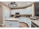 Modern kitchen with white cabinets, island, stainless steel appliances, and wooden floor at 823 Safflower Ct, Henderson, NV 89015