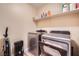A convenient laundry room with modern washer and dryer units, with a shelf for storing supplies at 823 Safflower Ct, Henderson, NV 89015