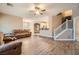Open living space features wood floors, neutral paint, ceiling fan, and a staircase leading to the upper level at 823 Safflower Ct, Henderson, NV 89015