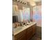 Bright bathroom with double sinks, decorative shower curtain, and tiled backsplash at 8408 W Gilmore Ave, Las Vegas, NV 89129