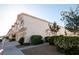 Exterior side view of condominium showing garage entrances, sidewalk and bushes at 8628 Tomnitz Ave # 101, Las Vegas, NV 89178