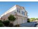 Exterior front side view of three car garage condo with sidewalk and green bushes at 8628 Tomnitz Ave # 101, Las Vegas, NV 89178