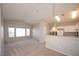 Open floor plan: living room with kitchen in background with white cabinets and appliances at 8628 Tomnitz Ave # 101, Las Vegas, NV 89178