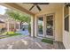 Covered patio area with tiled floor, ceiling fan, and double doors that lead to the interior of the house at 9262 Edgeworth Pl, Las Vegas, NV 89123