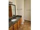 Bathroom features a granite countertop vanity with tile flooring and dark wood cabinets at 9325 W Desert Inn Rd # 233, Las Vegas, NV 89117