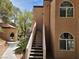 Beige stucco two-story building with outside staircase and arched windows on a partly cloudy day at 9325 W Desert Inn Rd # 233, Las Vegas, NV 89117