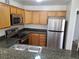 Well-lit kitchen features stainless steel appliances and speckled granite countertops with oak cabinets at 9325 W Desert Inn Rd # 233, Las Vegas, NV 89117