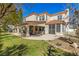 Spacious backyard featuring a covered patio, green lawn, and mature trees at 9517 Spanish Steps Ln, Las Vegas, NV 89117