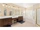 Well-lit bathroom with double sinks, granite countertops, and separate tub at 9517 Spanish Steps Ln, Las Vegas, NV 89117