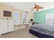 Bright bedroom with a decorative ceiling fan, multiple windows, and a built-in desk area at 9517 Spanish Steps Ln, Las Vegas, NV 89117
