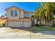 Charming two-story home with a three-car garage, mature palm tree, and well-manicured lawn at 9517 Spanish Steps Ln, Las Vegas, NV 89117