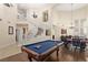 Spacious game room featuring a pool table, poker table, and curved staircase at 9517 Spanish Steps Ln, Las Vegas, NV 89117