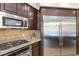 Modern kitchen with stainless steel appliances, granite countertops, and dark wood cabinets at 9517 Spanish Steps Ln, Las Vegas, NV 89117