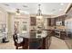 Bright kitchen with dark cabinets, large island, and stainless steel appliances, leading to a patio area at 9517 Spanish Steps Ln, Las Vegas, NV 89117