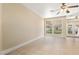Bright, airy living room with tile flooring, a ceiling fan, and a large window at 9517 Spanish Steps Ln, Las Vegas, NV 89117