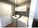 Efficient laundry room featuring a washer, dryer, and overhead storage cabinets at 981 Leadville Meadows Dr, Henderson, NV 89052