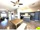Open-concept living room with hardwood floors flows into a kitchen with gray cabinets and a center island at 981 Leadville Meadows Dr, Henderson, NV 89052