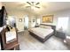 Main bedroom showcasing neutral carpet, ceiling fan, and a large bed with bedside tables at 981 Leadville Meadows Dr, Henderson, NV 89052