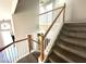 Carpeted stairs with wood banister and a view of the second floor at 981 Leadville Meadows Dr, Henderson, NV 89052