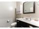 Bathroom with a single sink vanity, white countertop, dark cabinets, a mirror, a toilet, and gray walls at 10126 Cliff Dwellings Ave, Las Vegas, NV 89178