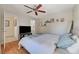 Bedroom featuring hardwood floors, ceiling fan and plush bed complemented by natural light at 10374 Midnight Iris St, Las Vegas, NV 89183