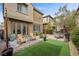 Charming backyard with artificial turf, a stone patio, and comfortable seating area at 11322 Corsica Mist Ave, Las Vegas, NV 89135