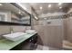 A bathroom featuring a double vanity with vessel sinks, a glass shower door, and stylish tiling at 11322 Corsica Mist Ave, Las Vegas, NV 89135