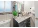 Contemporary bathroom with a dark vanity, quartz counter, and an oval mirror at 1312 Frost Flower Dr, North Las Vegas, NV 89032