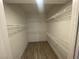 Spacious walk-in closet featuring white walls, wood-look flooring, and wire shelving throughout at 1505 Blackcombe St # 103, Las Vegas, NV 89128