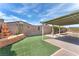 Backyard with a water feature, covered patio, lush artificial grass, and brick pavers at 2151 Babylon Mill St, Henderson, NV 89002