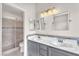 Contemporary bathroom with dual sinks, decorative tile backsplash, and walk-in shower with glass door at 2151 Babylon Mill St, Henderson, NV 89002