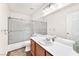 Bright bathroom featuring a tub with sliding glass doors, single sink and a large mirror at 2151 Babylon Mill St, Henderson, NV 89002