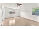 Light-filled bedroom with wood floors, a ceiling fan, and two windows at 2151 Babylon Mill St, Henderson, NV 89002