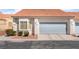 Charming home exterior featuring a tile roof, neutral stucco, a gray garage door, and manicured landscaping at 2246 Cassatt Dr, Henderson, NV 89074