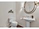 Elegant half bathroom with a pedestal sink, decorative mirror, and neutral color palette at 2405 W Serene Ave # 817, Las Vegas, NV 89123