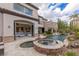 Expansive backyard showcasing a pool, spa, and open doors to the home's interior at 2436 Grassy Spring Pl, Las Vegas, NV 89135
