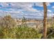 Backyard view of lake and golf course with lush landscaping and blue skies at 2436 Grassy Spring Pl, Las Vegas, NV 89135