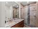 Modern bathroom featuring granite counters, stone shower with glass door, and updated fixtures at 2436 Grassy Spring Pl, Las Vegas, NV 89135