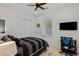 Bright bedroom with a simple aesthetic includes a striped bedspread, desk, and double closet at 2436 Grassy Spring Pl, Las Vegas, NV 89135