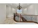 Elegant foyer with a curved staircase, detailed iron railings, and ornate chandelier lighting at 2436 Grassy Spring Pl, Las Vegas, NV 89135