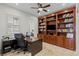This home office boasts custom wood shelving, a ceiling fan, and a large desk at 2436 Grassy Spring Pl, Las Vegas, NV 89135