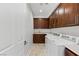 This laundry room has wood cabinets, a sink, and a washer and dryer at 2436 Grassy Spring Pl, Las Vegas, NV 89135