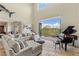 Bright living room with large windows offering backyard views, comfortable seating, and a grand piano at 2436 Grassy Spring Pl, Las Vegas, NV 89135