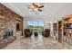 Open living room featuring brick accent wall, built-in bookshelves, and outdoor view at 2436 Grassy Spring Pl, Las Vegas, NV 89135