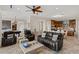 Open living area featuring leather furniture, tile flooring, and access to the kitchen and billiards room at 2436 Grassy Spring Pl, Las Vegas, NV 89135